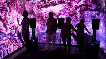 People standing in a Setl immersive multi-wall projection room